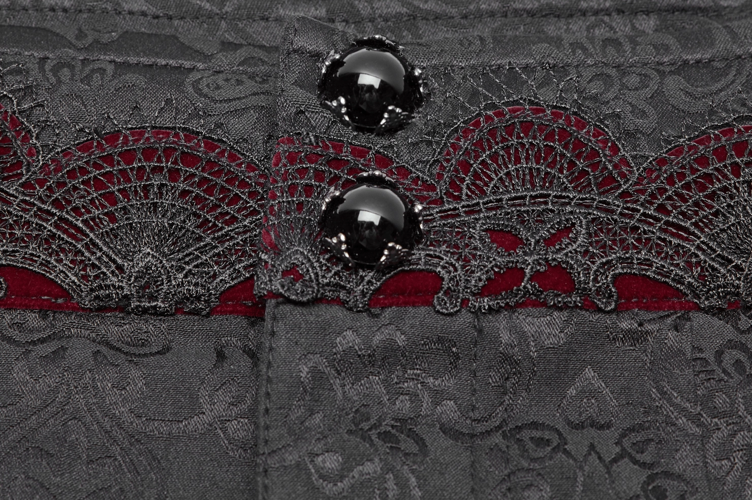 Black gothic jacquard slim-fit pants waist close-up showing gem-style metal buttons and red lace underlay detail