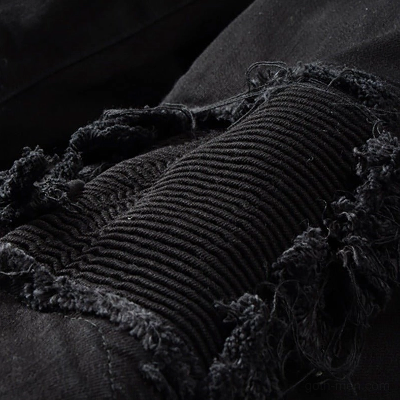 Knee distressed ripped patch detail showing frayed edges and ribbed inner fabric construction on black gothic denim
