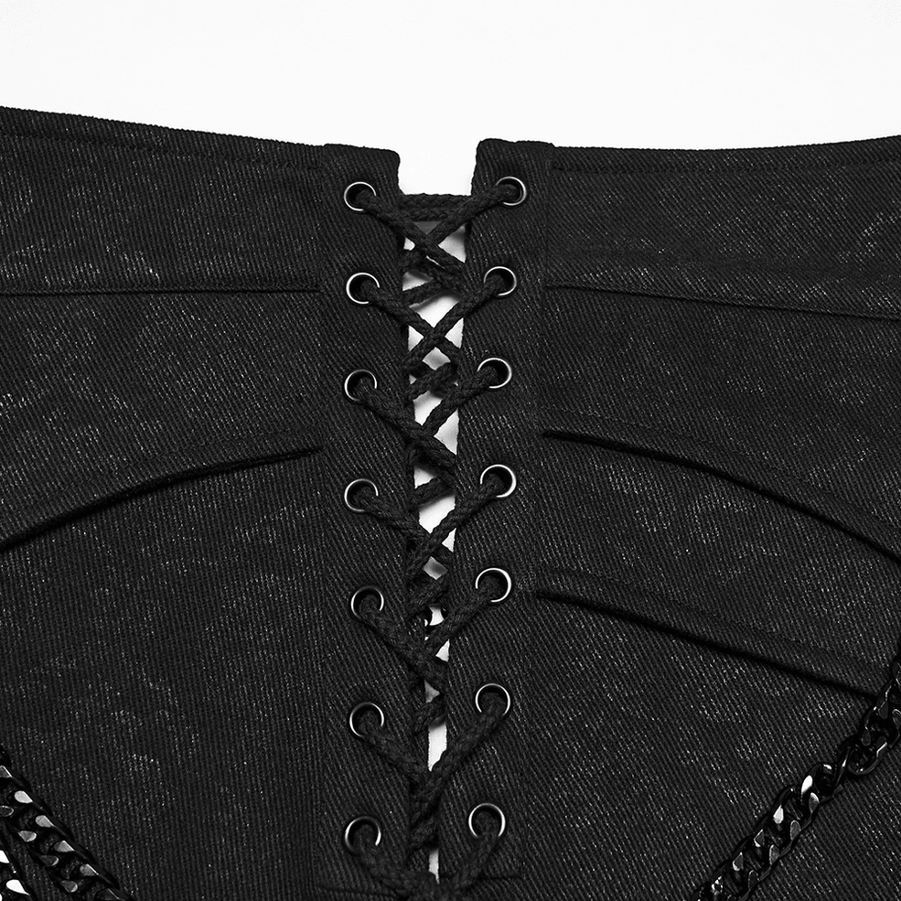 Black gothic kilt lace-up back detail showing woven lace cord with metal eyelets and chain trim macro close-up