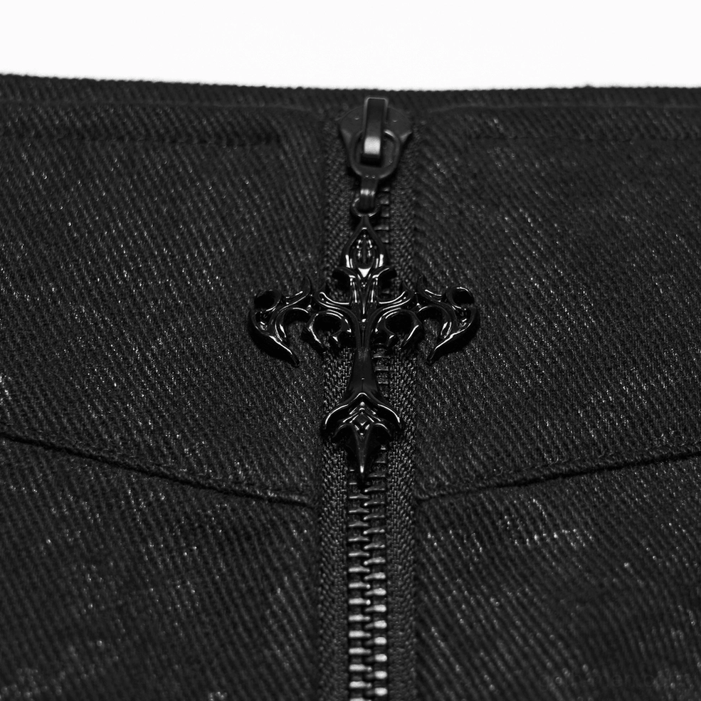Metal cross-shaped zipper hardware and embossed denim-style fabric macro close-up detail of black gothic kilt