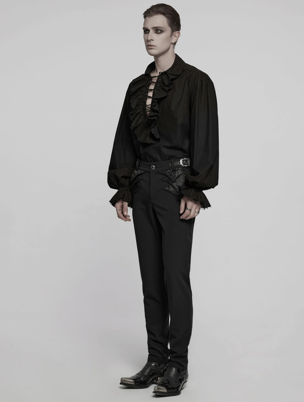 Black gothic lace trousers leg drape demonstration, highlighting fitted cut and vertical silhouette on flat lay
