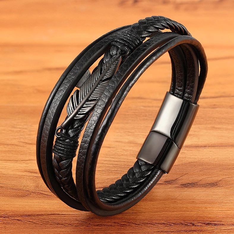 Black leather gothic bracelet with matte black feather decoration side angle view on wooden table