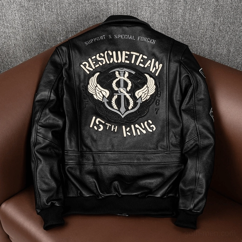 Black leather gothic jacket back view on sofa displaying rescue team embroidery and anchor wing patch