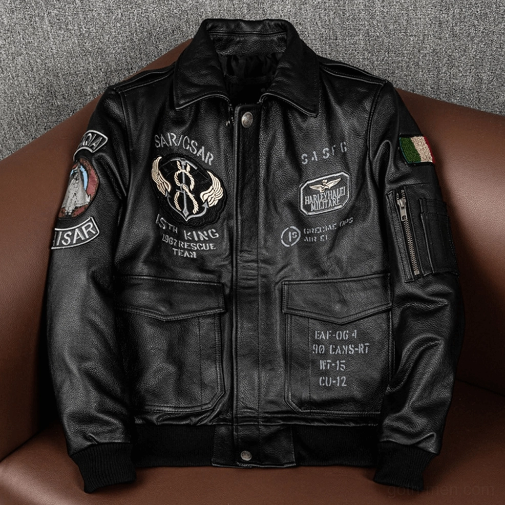 Black embroidered leather gothic motorcycle jacket on display sofa with front zipper and tactical patch details
