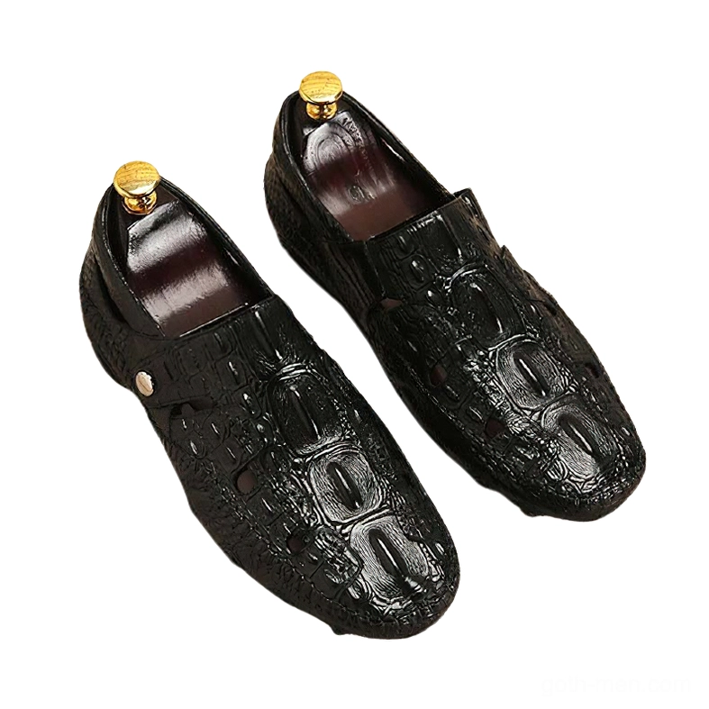 Pair of black crocodile-embossed gothic loafers in front three-quarter view, showing metal side buttons, architectural pleated details, and built-in shoe trees