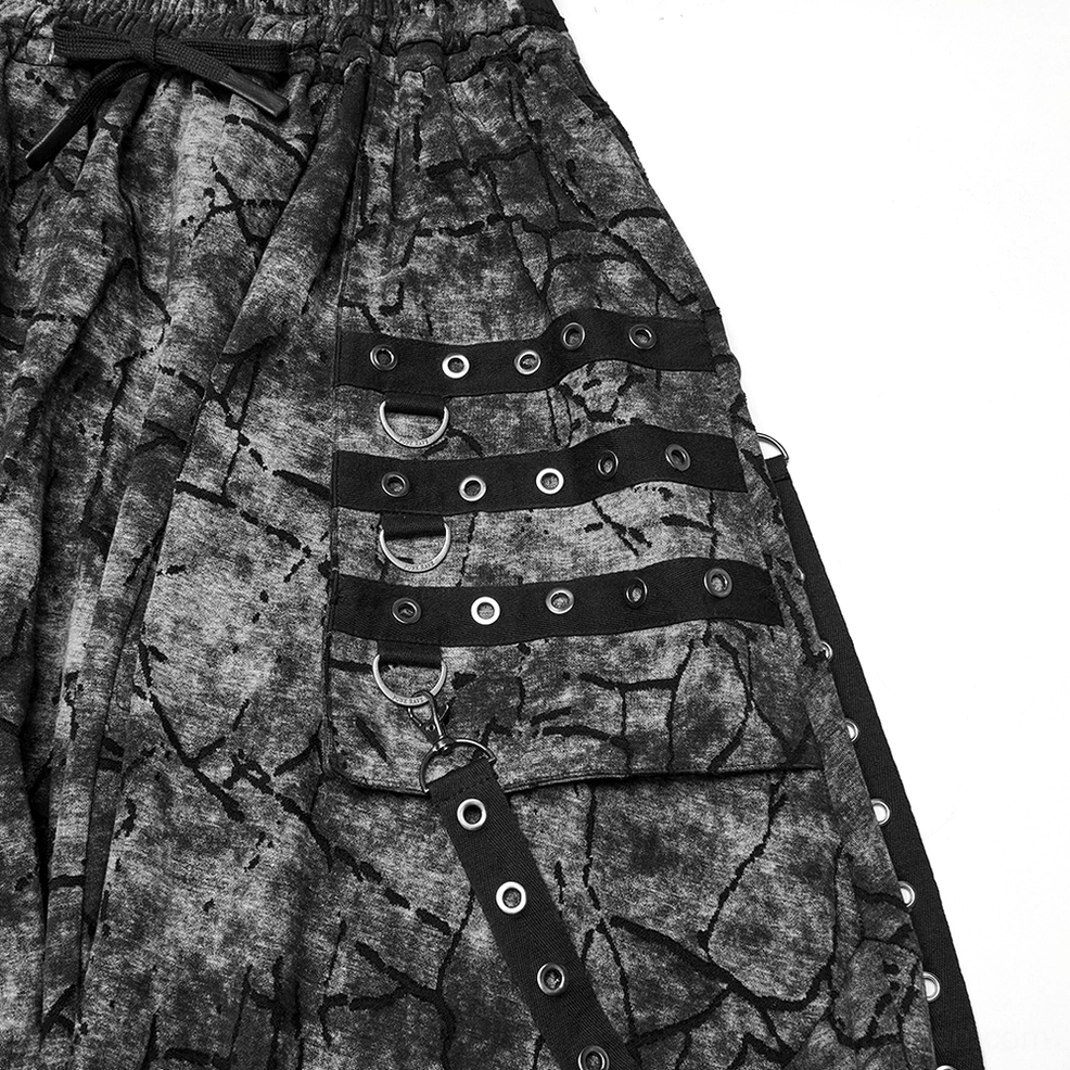 Close-up of eyelet strap hardware and metal grommets on black gothic harem pants cargo pocket