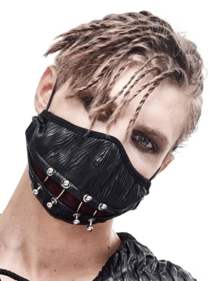 Gothic punk face mask with silver piercings worn by male model with dreadlocks, three-quarter front view showing wrinkled black fabric and metal ring accents