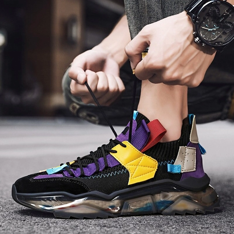 Black multicolor gothic platform sneaker with person tying laces indoors wearing wrist watch