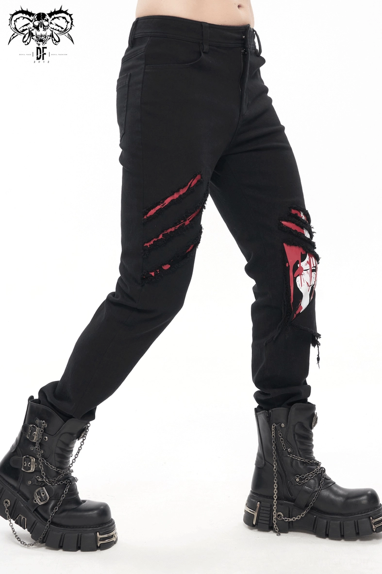 Black gothic ripped pants close-up showing fabric texture, tear details, and graphic print visibility