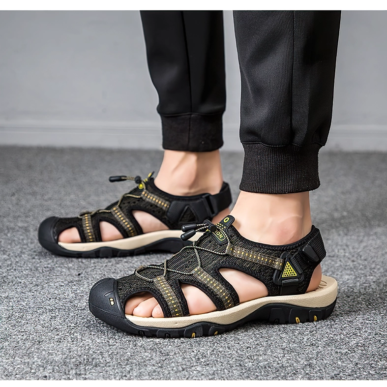 Black gothic gladiator sandals velcro ankle strap worn on feet grey carpet background