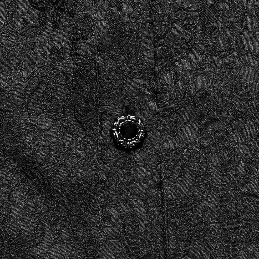 Close-up macro detail of black gothic shirt showing decorative gem-embellished button and jacquard fabric texture