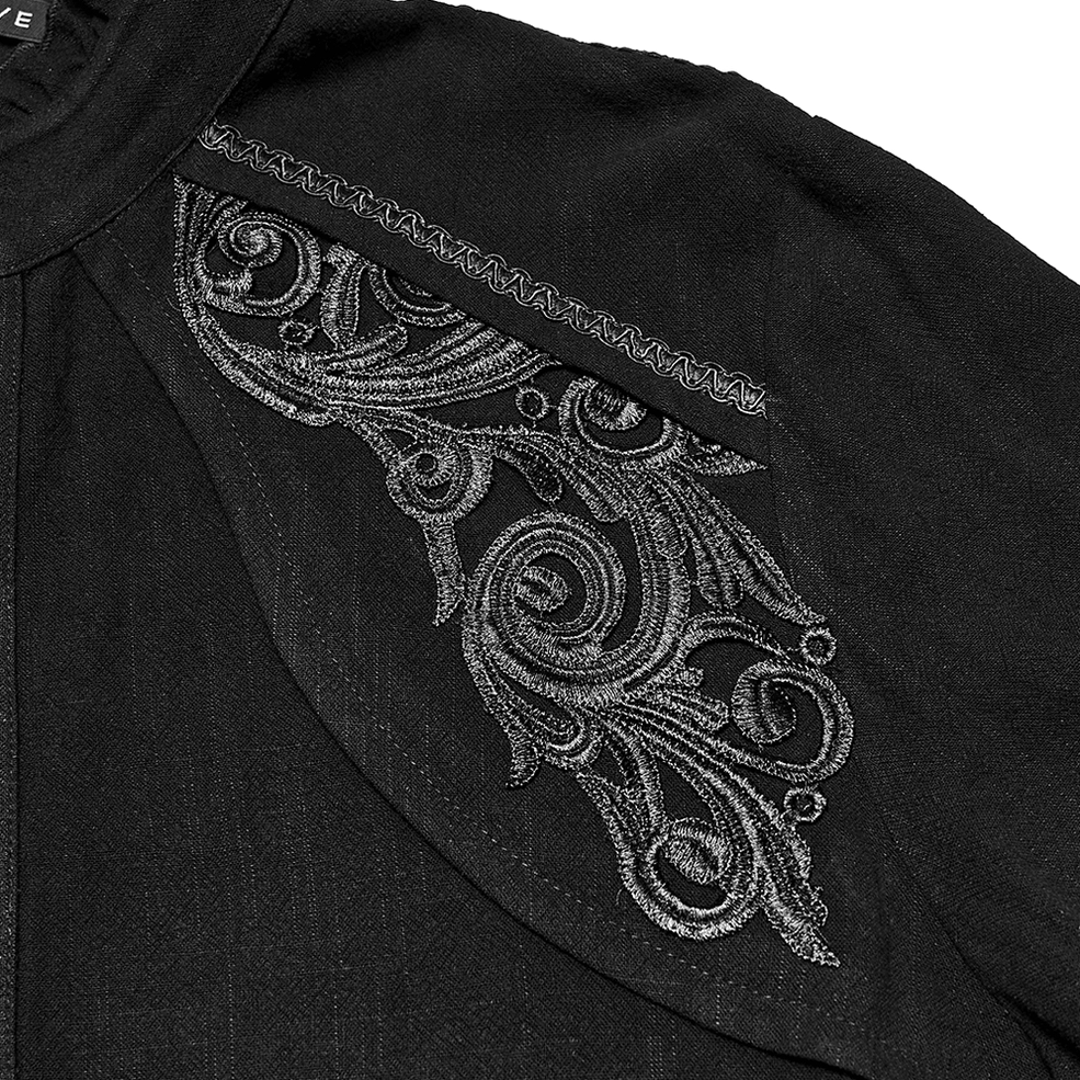 Detailed view of black gothic shirt shoulder embroidery featuring silver scroll work, decorative seam trim, and textured fabric construction