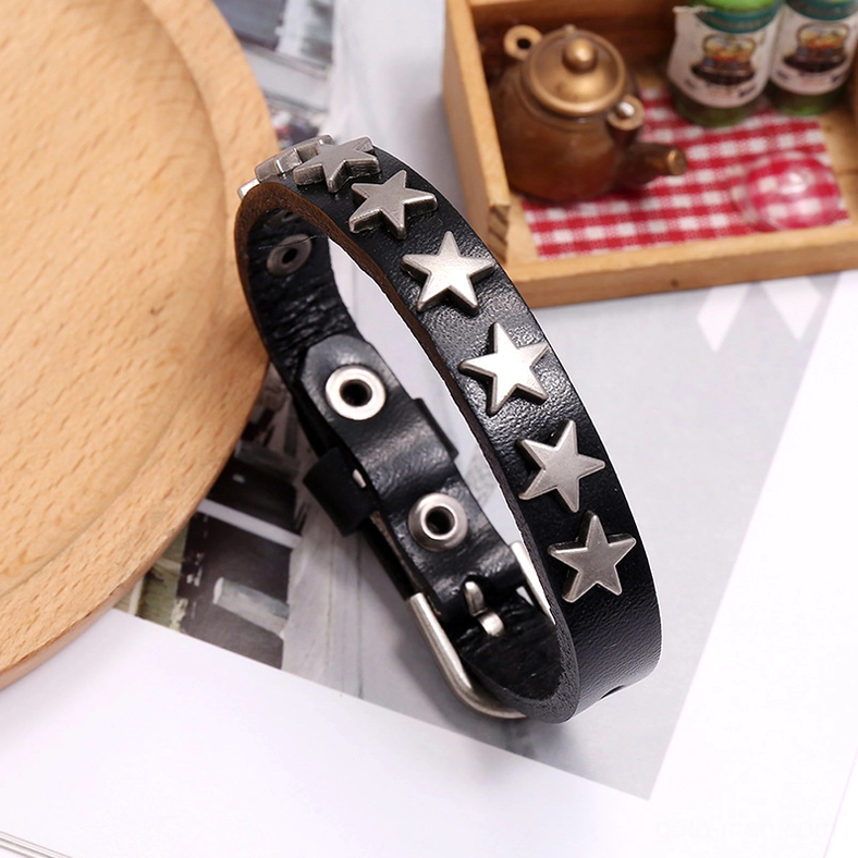 Black matte star leather gothic bracelet on decorated tabletop with antique tea set vintage backdrop and aesthetic styling