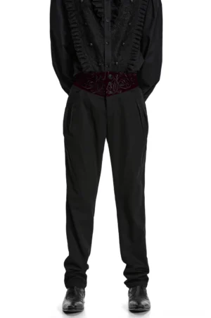 Black gothic slim-fit trousers with embroidered wine-red velvet waistband - front view on male model