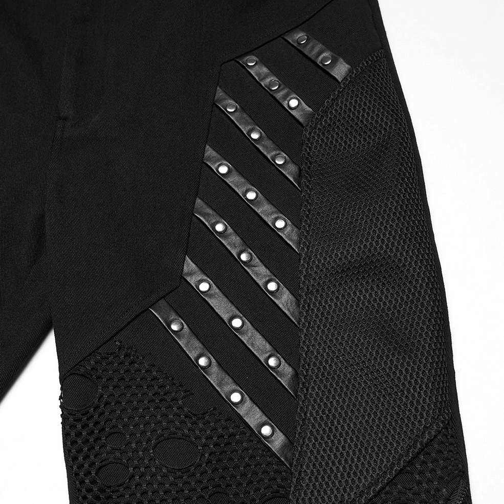 Close-up of black gothic pants metal rivet strips and mesh fabric accents