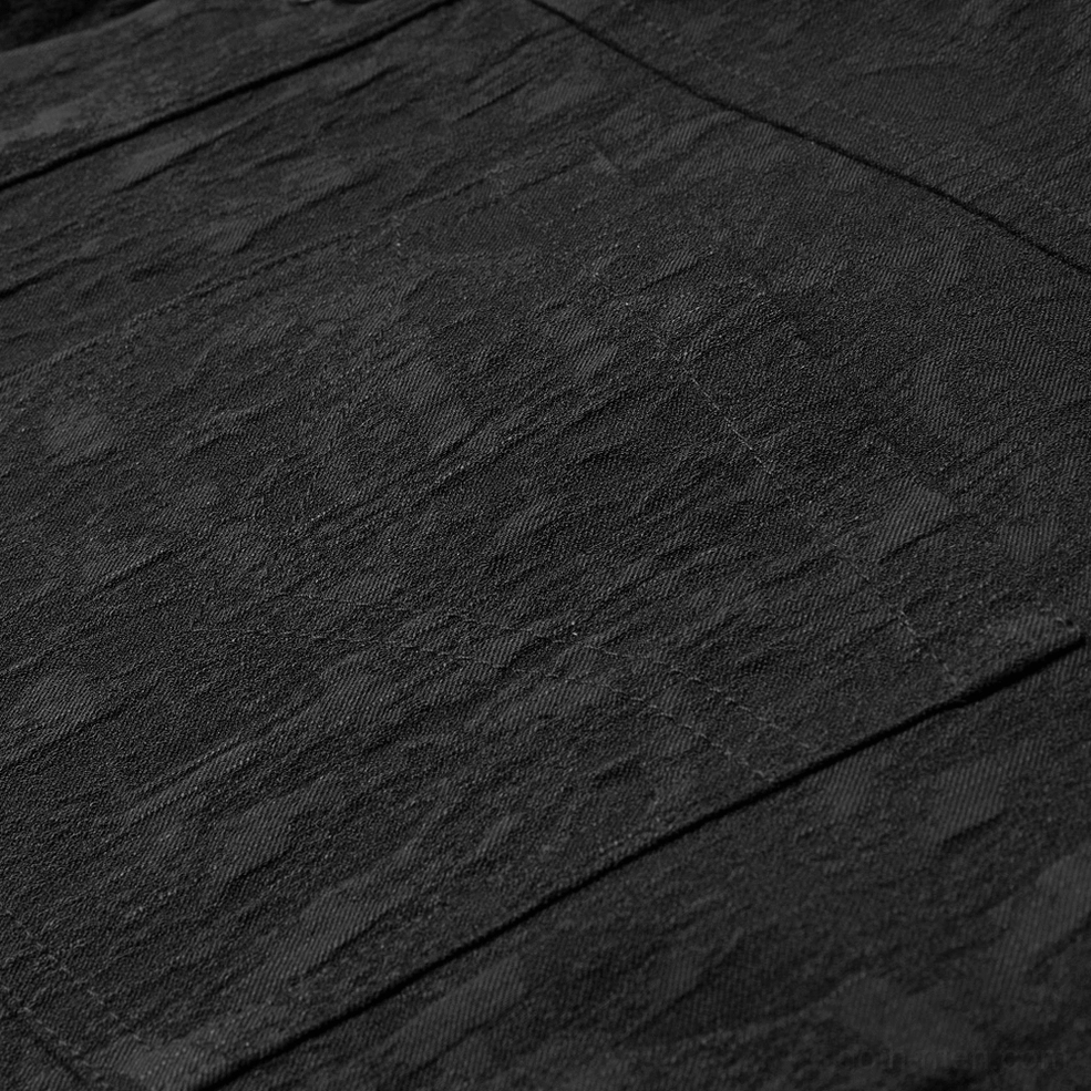 Black jacquard gothic shirt fabric close-up - tonal dark pattern weave on smooth woven surface