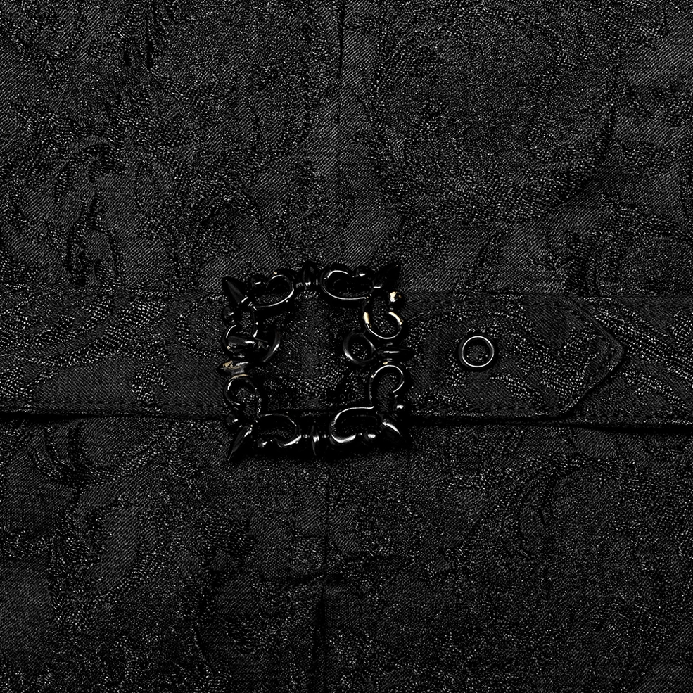 Close-up detail of ornate metal waist buckle and jacquard fabric texture on black gothic waistcoat