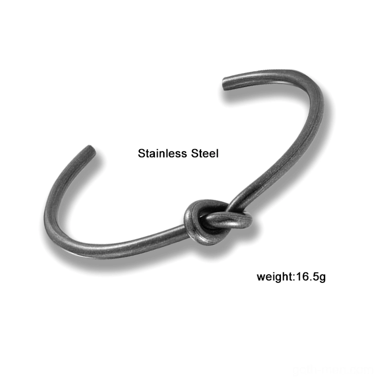 Black knotted open cuff bracelet stainless steel on white studio background flat lay product shot