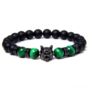 Black lava stone wolf charm bracelet with green tiger eye beads, gothic animal symbol, flat lay display on white background