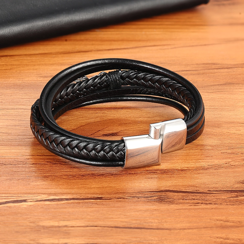 Multi-braid black leather gothic bracelet with silver magnetic clasp, top-down view on wooden table