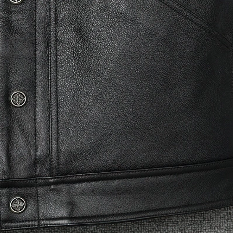 Bottom hem and cross-shaped metal snap buttons on black genuine leather gothic vest, showing garment construction details