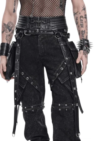 Male model wearing black leather body harness with metal D-rings and side utility pouches, front full-body view, tattooed torso, punk goth aesthetic