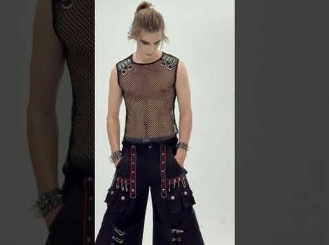Black mesh tank top styled with bondage trousers and layered bracelets on male goth model