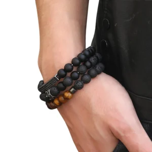 Unisex black onyx beaded bracelet with metal crown decoration styled on wrist against dark leather jacket background, side profile gothic jewelry