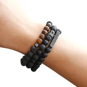 Black matte onyx stone beaded bracelet with vintage crown charm worn on male wrist, close-up top view showcasing gothic design and beaded detail