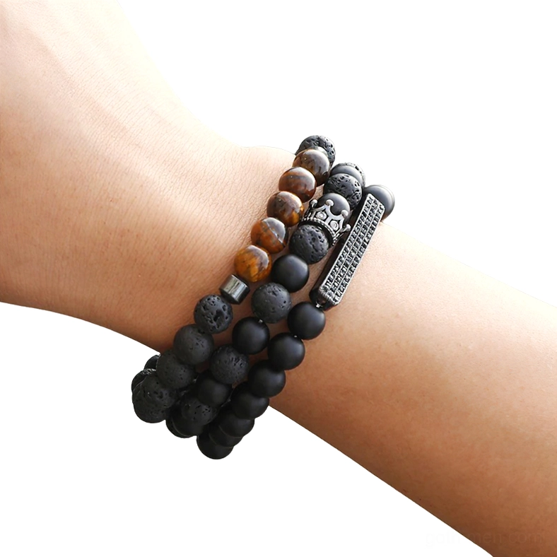 Black matte onyx stone beaded bracelet with vintage crown charm worn on male wrist, close-up top view showcasing gothic design and beaded detail