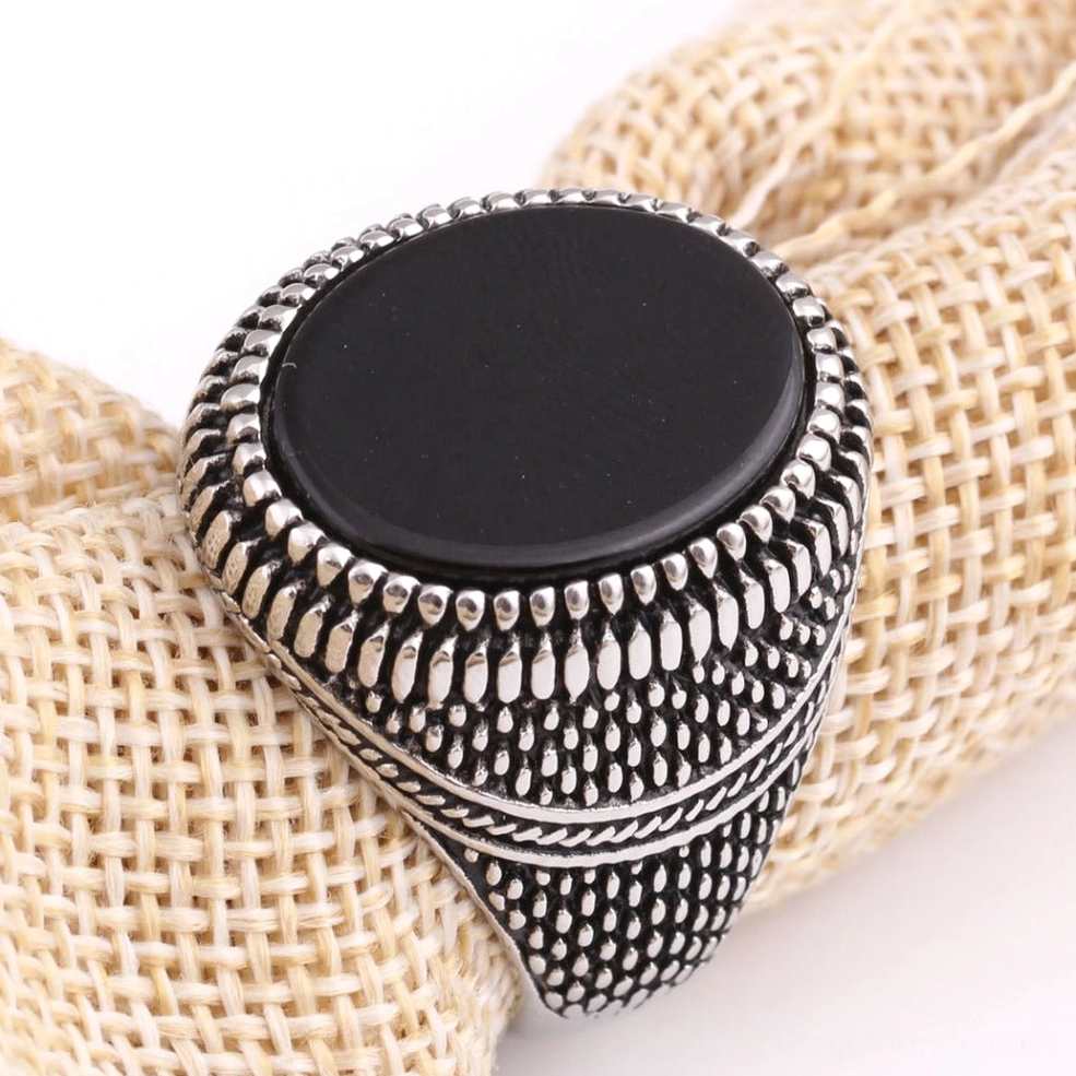 Black onyx gothic signet ring flat round stone top view linen fabric background