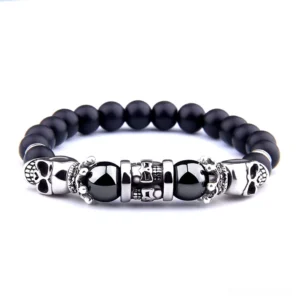 Black onyx skull beaded bracelet flat lay - gothic stone jewelry featuring vintage silver skull charms and elastic band construction