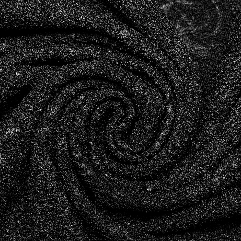 Macro close-up of soft knit paisley jacquard texture with subtle dark sheen all-black tones