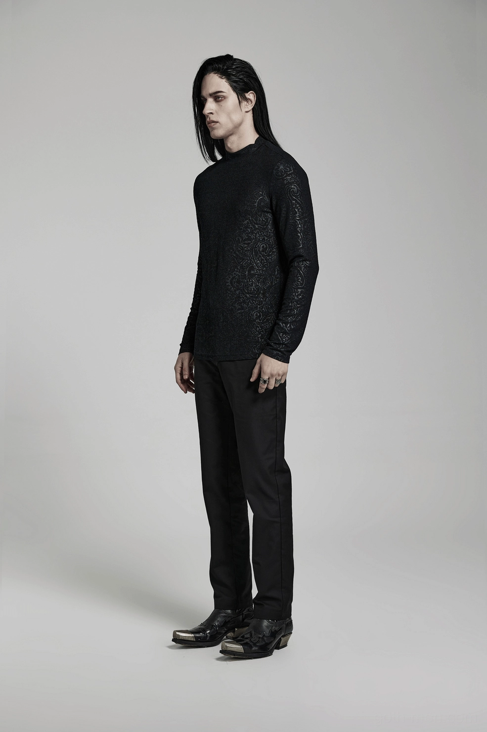 Male model wearing black paisley gothic mock neck top with layering styling and accessories