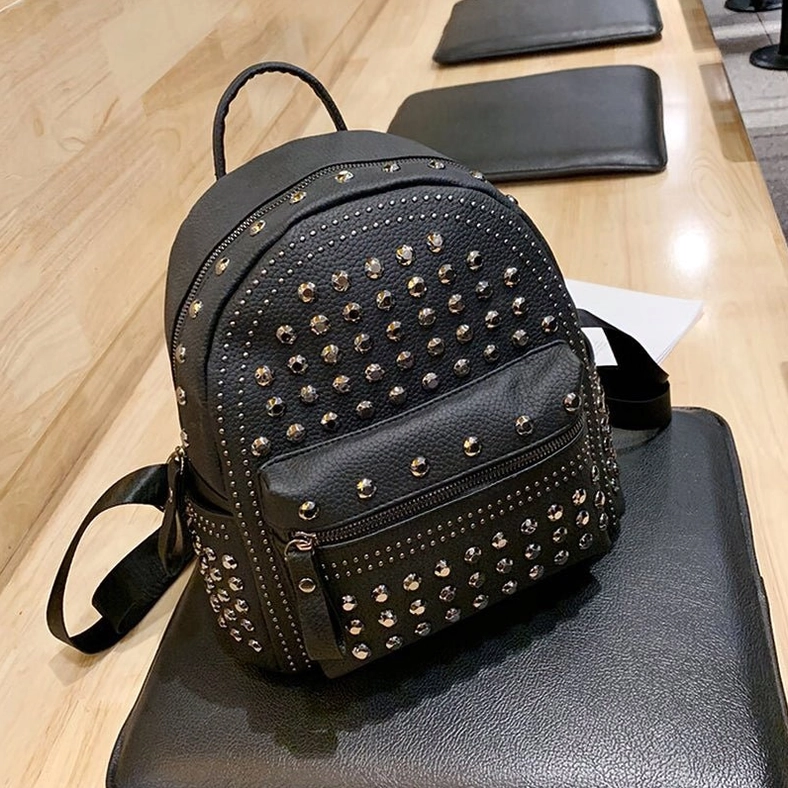 Black gothic rivet backpack three-quarter front angle showing full rivet placement and zipper details