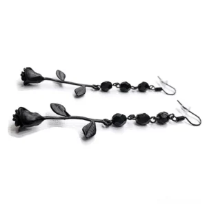 Two pairs of black rose dangle earrings with beaded chain detail, top-down flat lay view showing fishhook ear wires