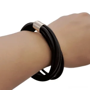 Black rubber gothic bangle bracelet with rose gold clasp, side close-up view on female wrist showcasing layered silicone design