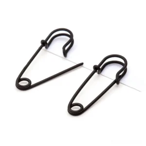 Matte black gothic safety pin stud earrings flat lay detail shot, minimalist punk rock design