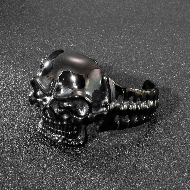 Polished black metal skull cuff bracelet front three-quarter view highlighting intricate carving details
