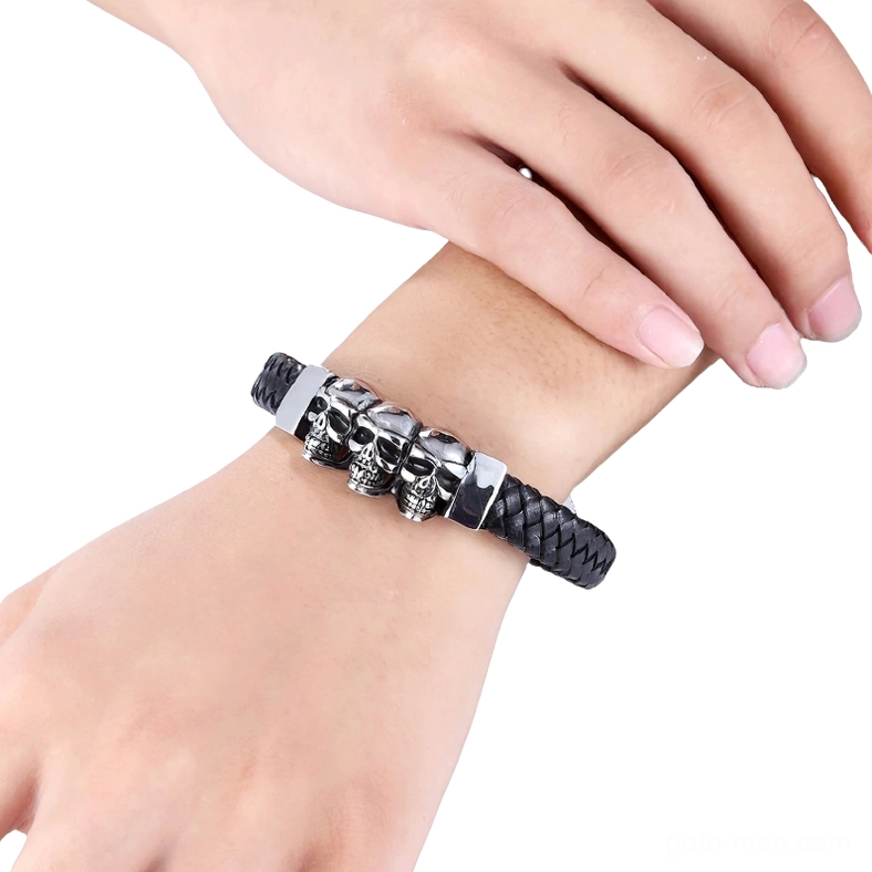Men's black braided leather skull bracelet worn on male hand, side wearing view showing silver skull details and magnetic closure