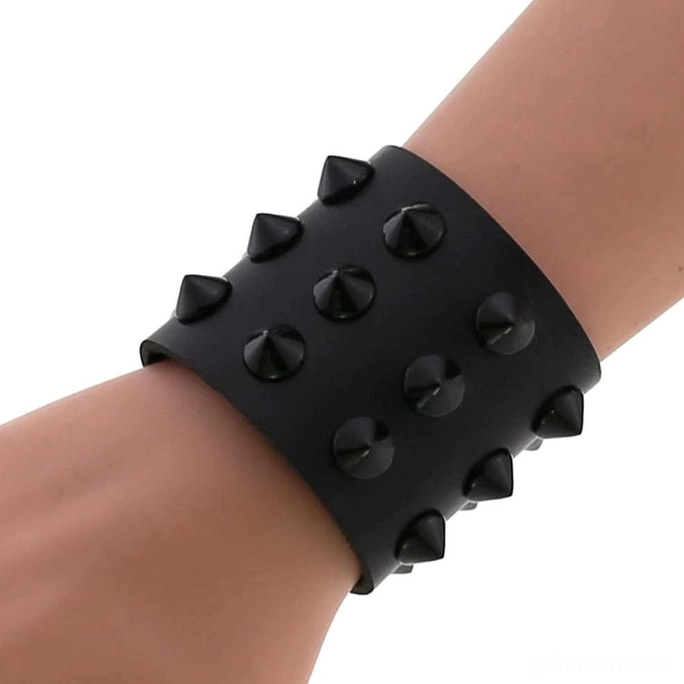 Black spike studded wide wrap bracelet on wrist - side view showing adjustable snap button closure and cone spike details