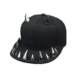 Black spiked studded snapback cap with silver metal spikes on crown and brim, left three-quarter view showing gothic punk rock baseball cap design