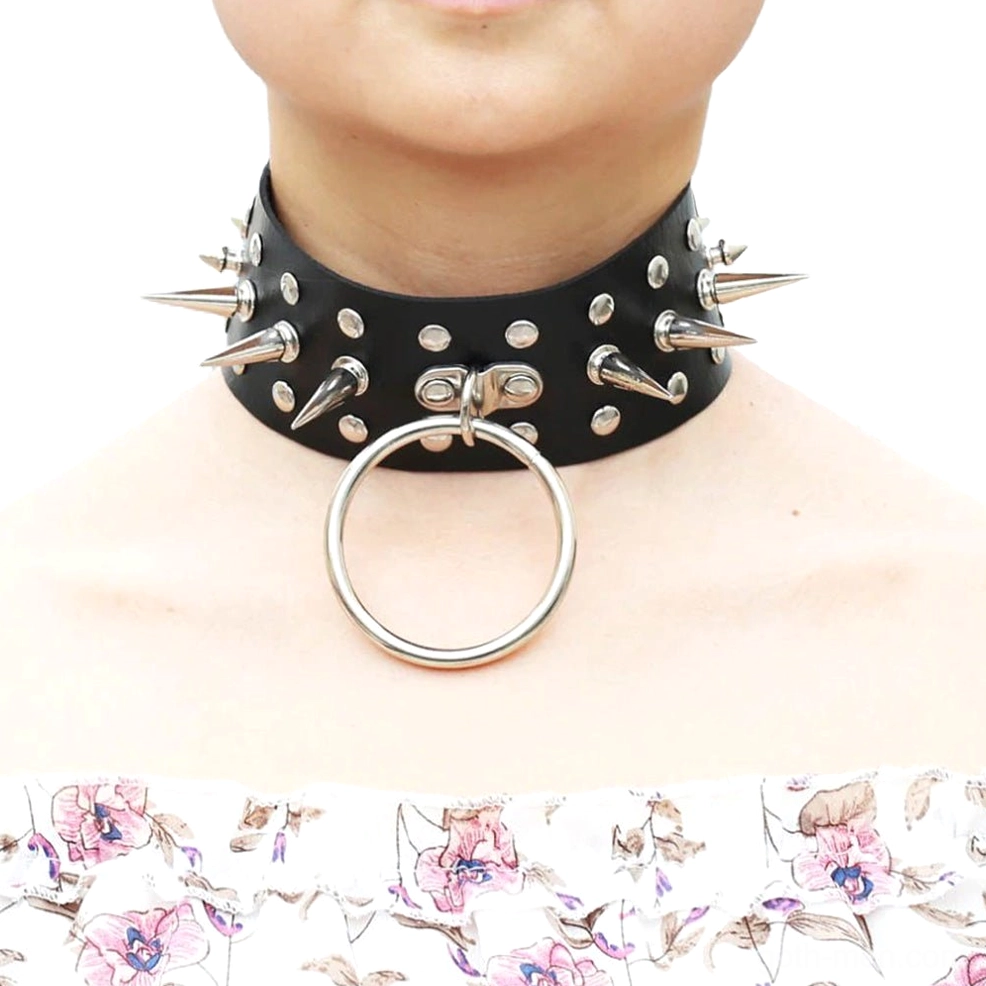 Black oversized spiked choker on model wearing floral top, close-up front view showing metal spike and O-ring detail