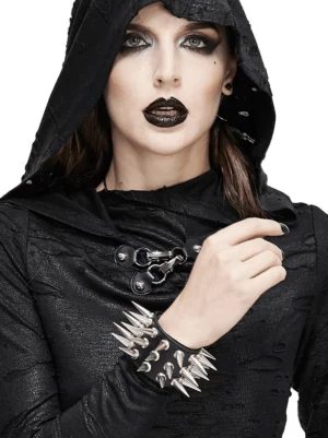 Female gothic model wearing black spiked leather bracelet with silver cone spikes in studio setting