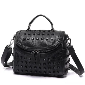 Black studded sheepskin messenger bag front three-quarter view showing dual zippers and metal rivet detailing
