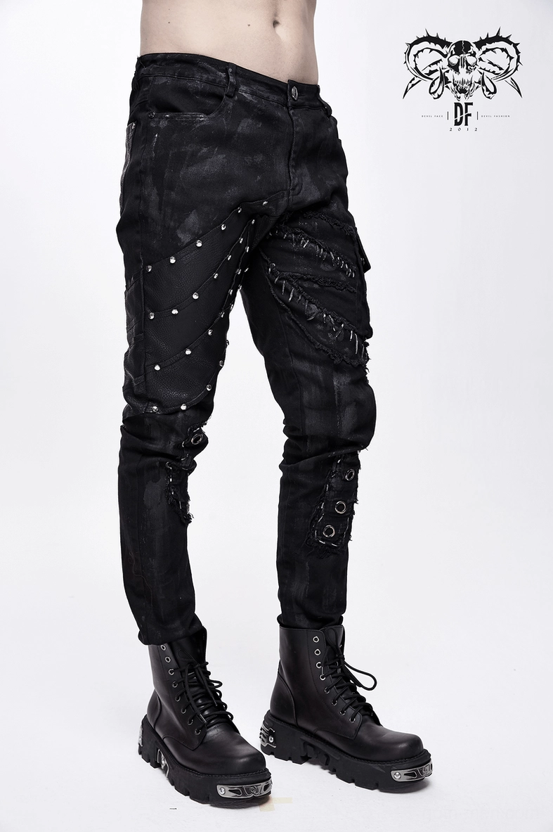 Distressed black denim punk pants highlighting silver rivet and eyelet craftsmanship