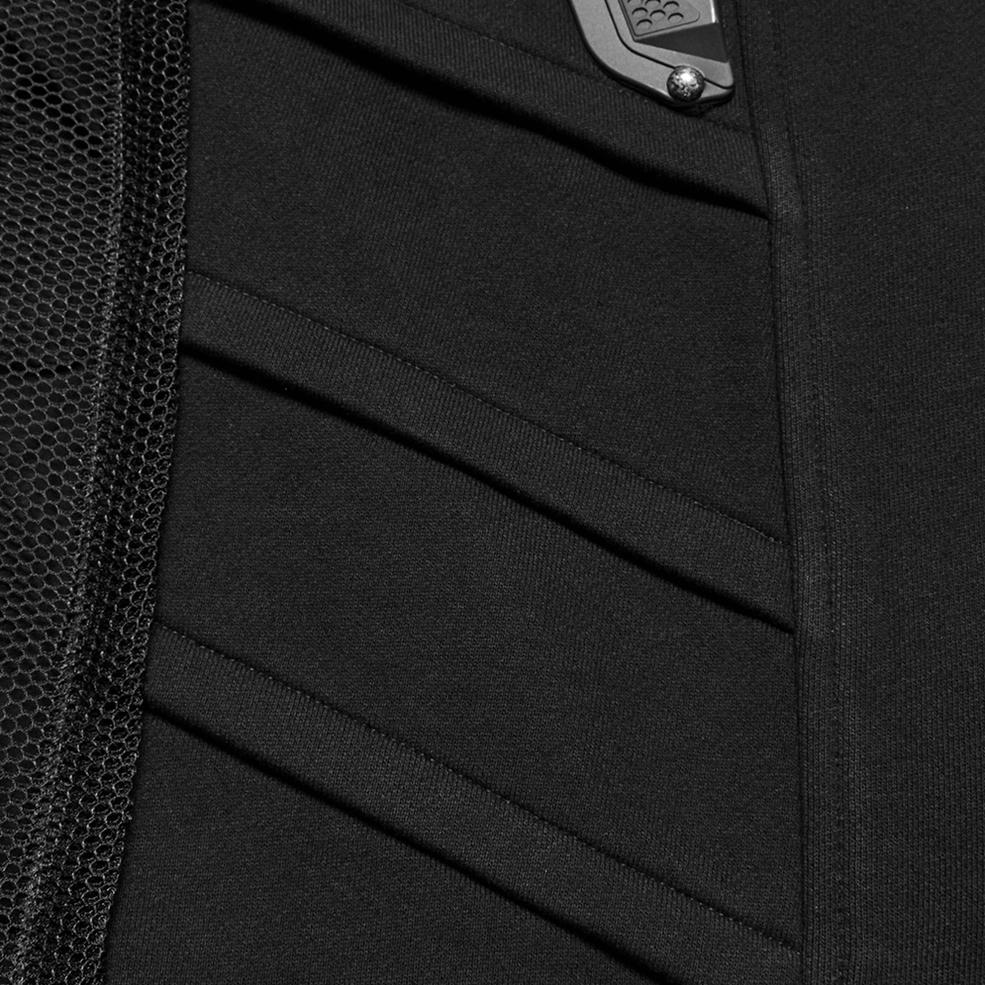 Macro detail shot of black tactical vest side seams showing mesh fabric panels and stitching