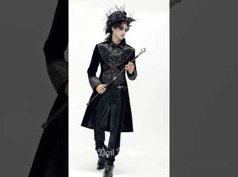 Gothic male model wearing black tailcoat with cosplay headpiece and walking cane theatrical styling