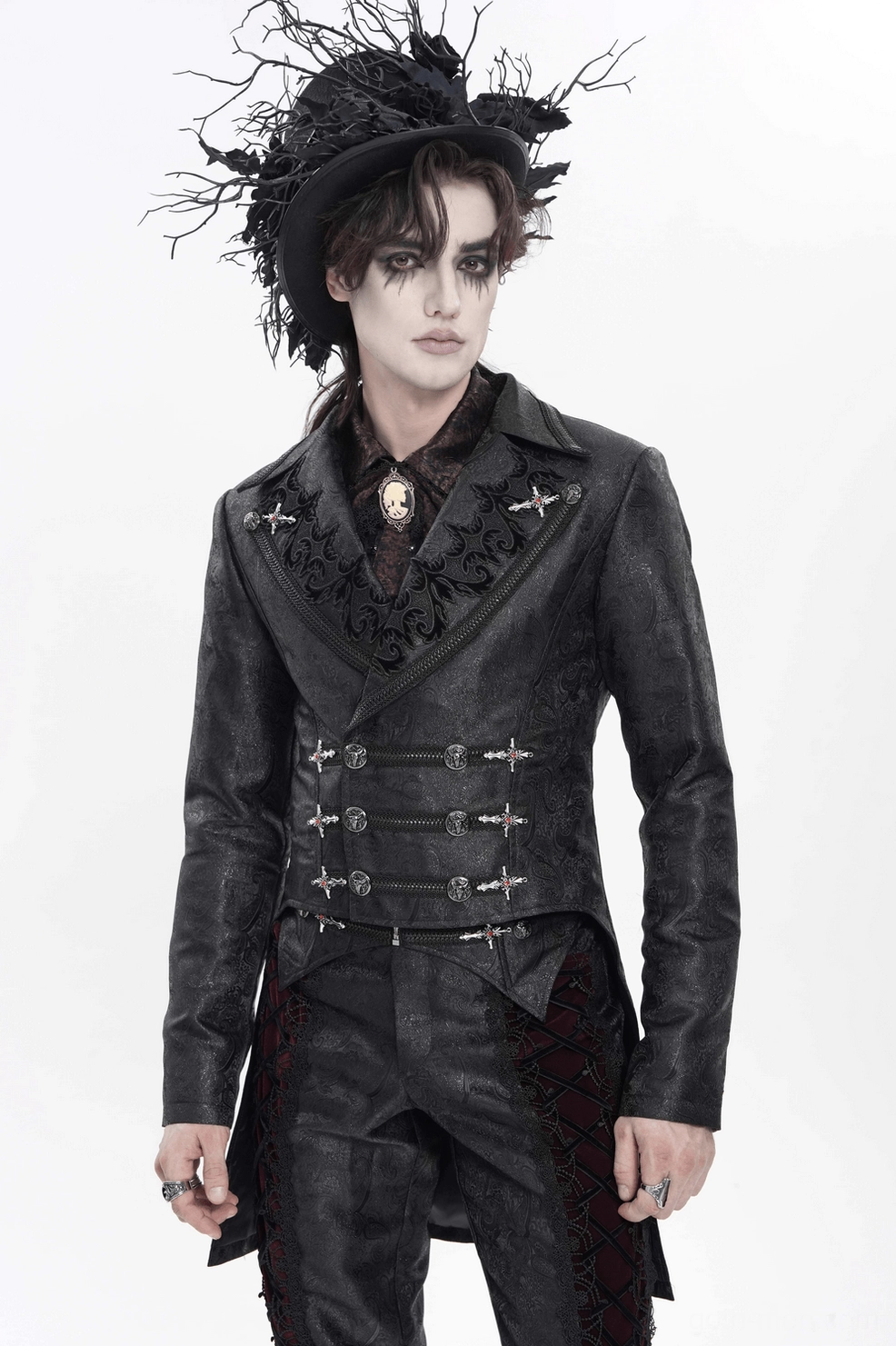 Black gothic tailcoat worn by male model - front angled studio shot showing cross buckles, embroidered details, and fitted silhouette