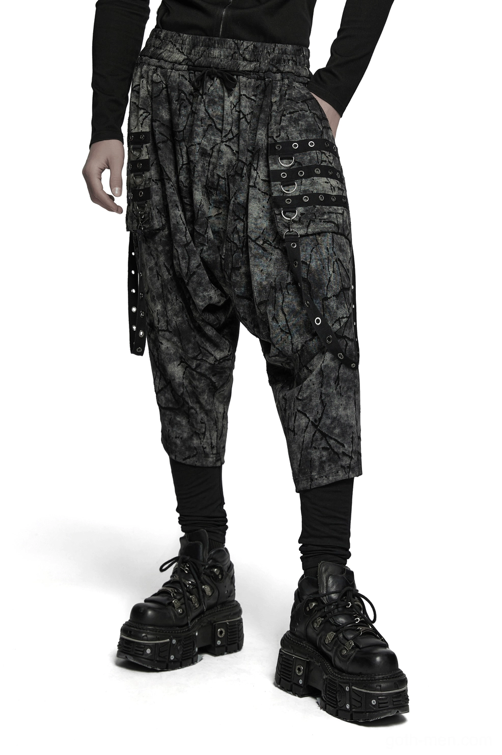 Black tie-dye gothic harem pants front view worn by male model showing drop crotch silhouette and eyelet cargo pockets